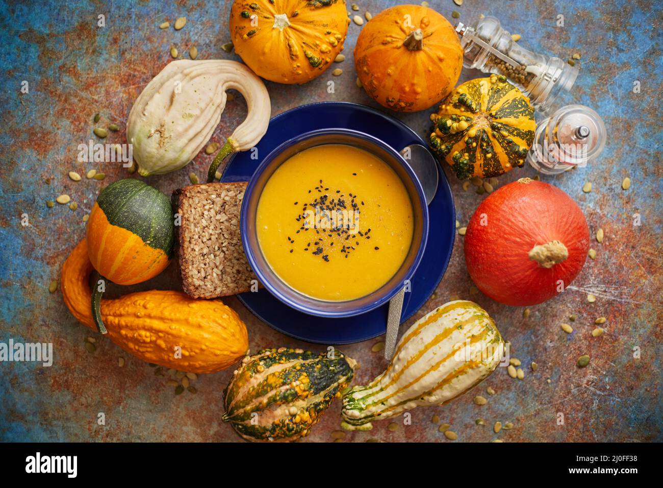 Compositon con cibo classico autunnale. Gustosa zuppa di zucca fatta in casa decorata con semi neri Foto Stock