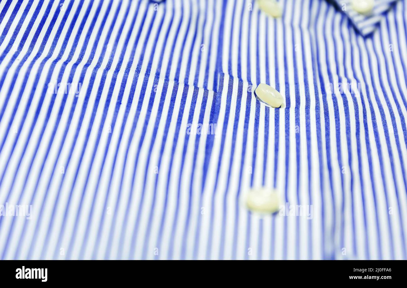 Il bottone di una camicia a righe blu con un colletto con un bottone rivolto verso il basso Foto Stock