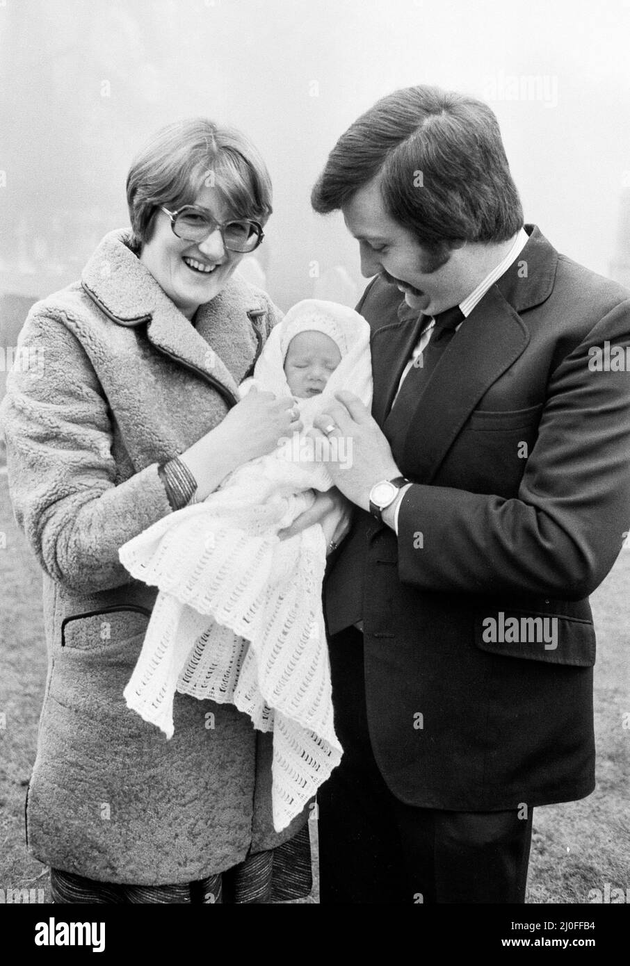 PC Graham Browne e sua moglie Yvonne posano con il loro figlio di otto settimane Clive Brown dopo la sua cerimonia di Natale alla chiesa di Sandringham, Norfolk. Alla cerimonia hanno partecipato anche i membri della Famiglia reale, tra cui la Regina, che soggiornano a Sandringham durante il periodo di Natale e Capodanno. Per coincidenza, il battesimo si è svolto negli stessi giorni del servizio familiare, portando undici membri della Famiglia reale a partecipare al battesimo. 8th gennaio 1978. Foto Stock