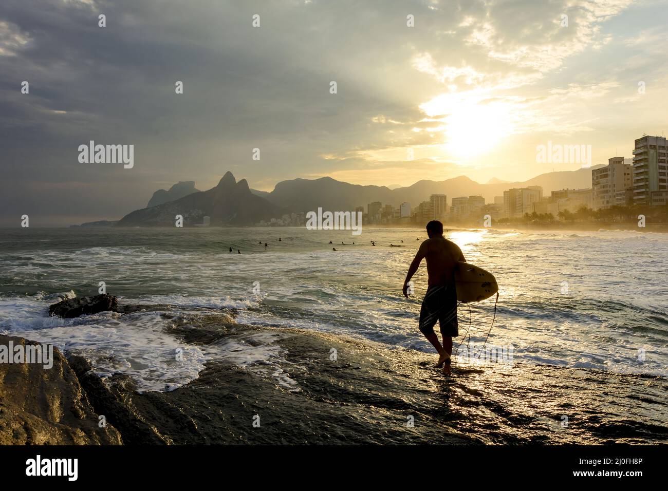 Surfista sulla spiaggia di Ipanema al tramonto Foto Stock