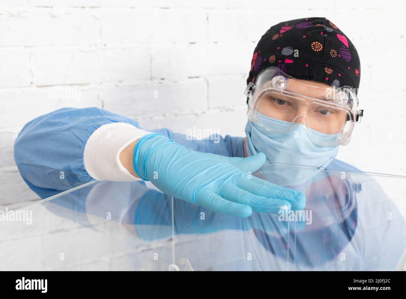 Il dipendente durante la disinfezione cerca di pulire accuratamente ogni centimetro della scatola di scrutinio per evitare l'infezione. Foto Stock