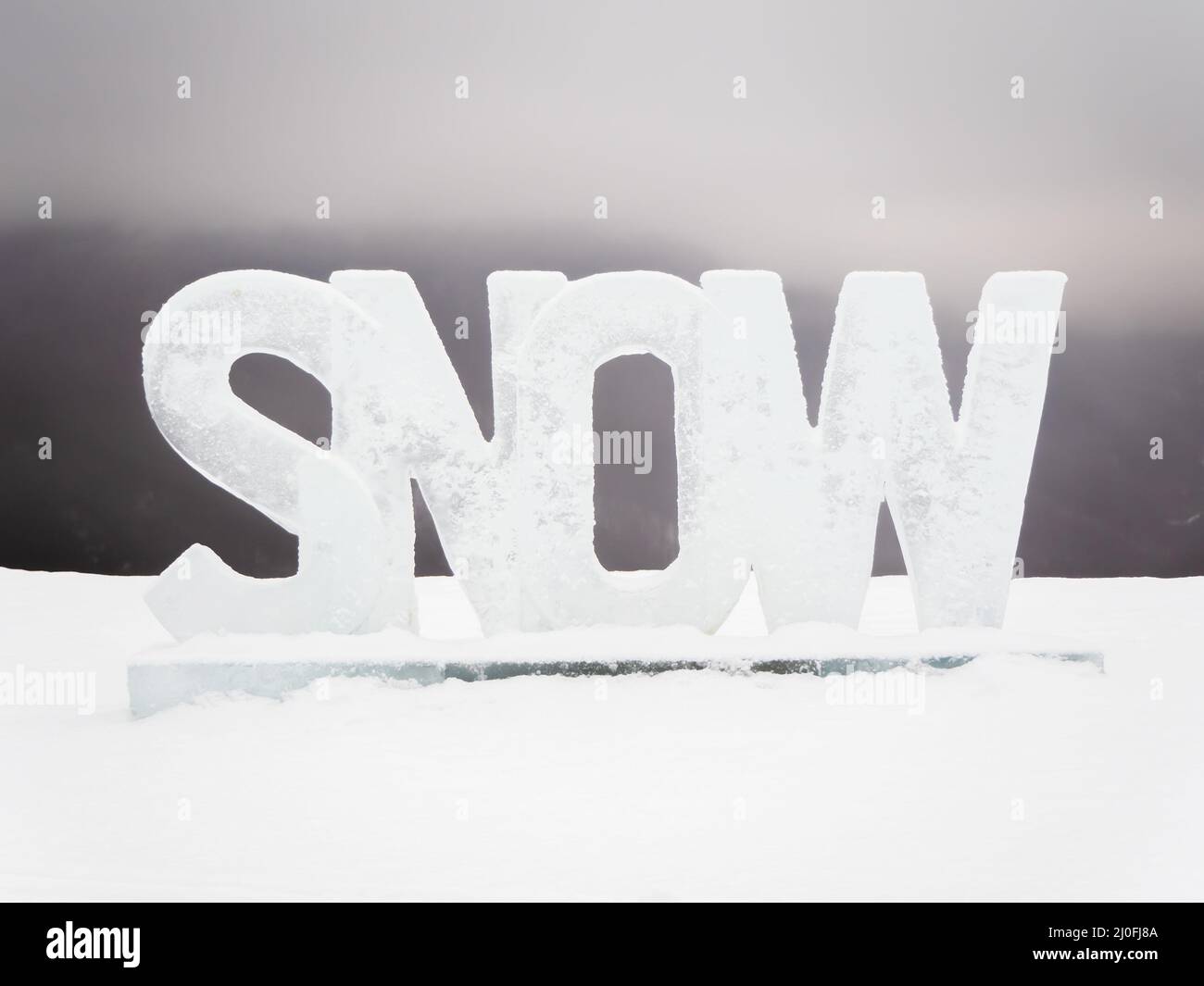 L'iscrizione neve tagliata da ghiaccio si trova sulla strada in una giornata invernale grigia Foto Stock