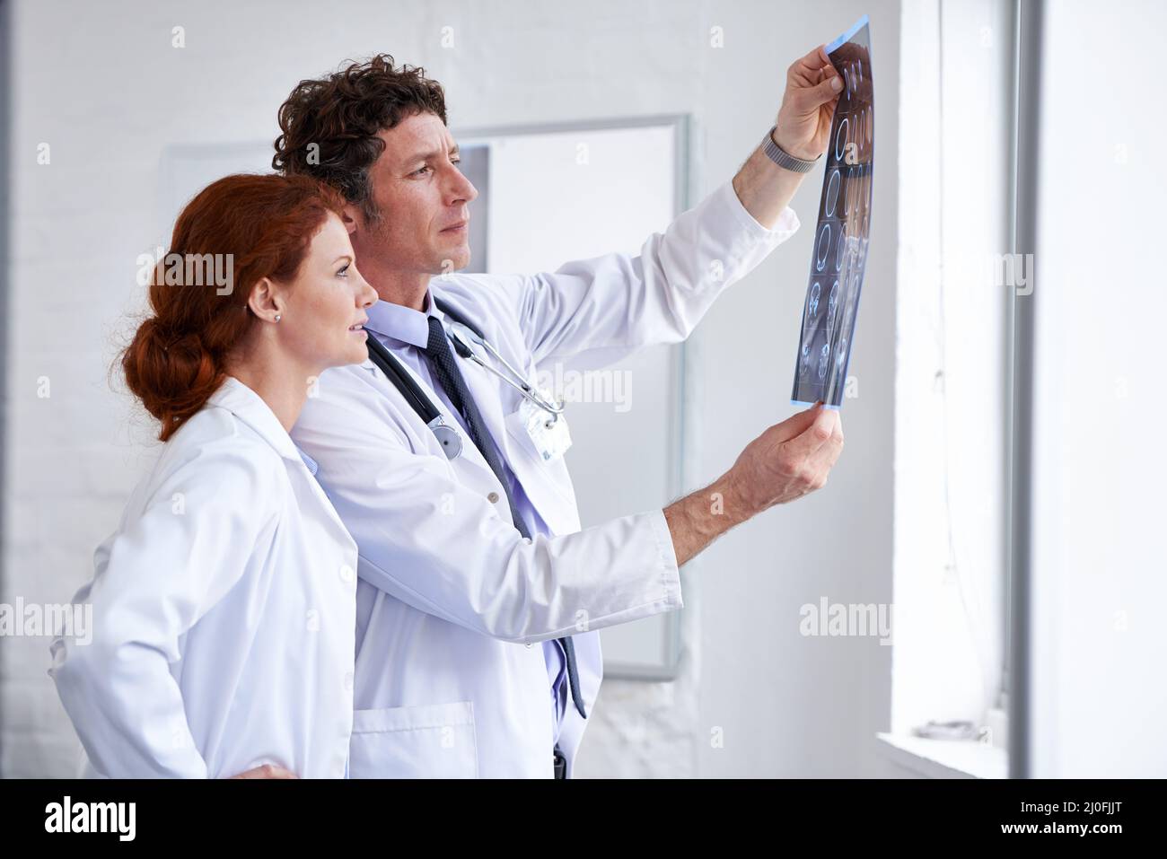 Imparare qualcosa di nuovo ogni giorno. Shot di due medici che valutano un paziente radiologico in ospedale. Foto Stock