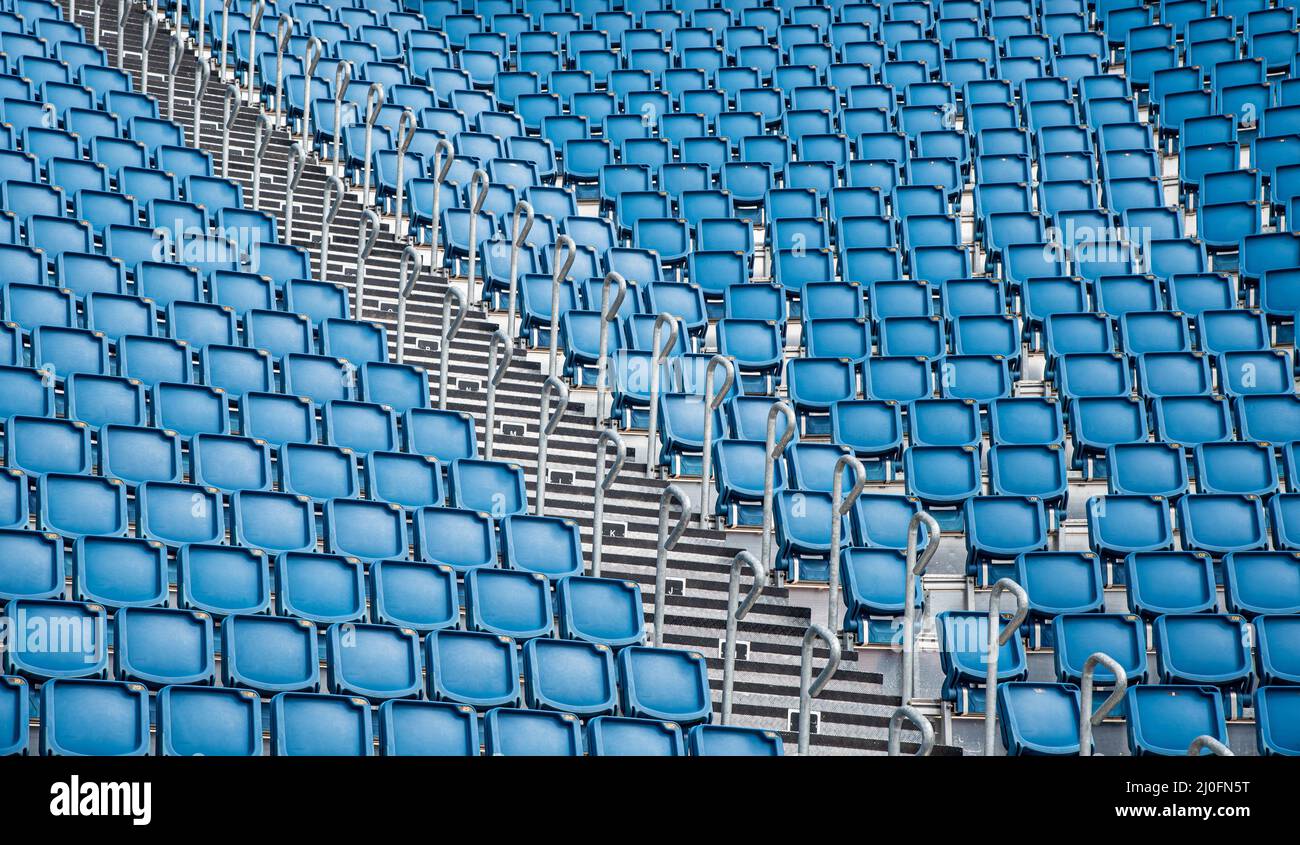 Sedie da stadio vuote in plastica blu di fila Foto Stock