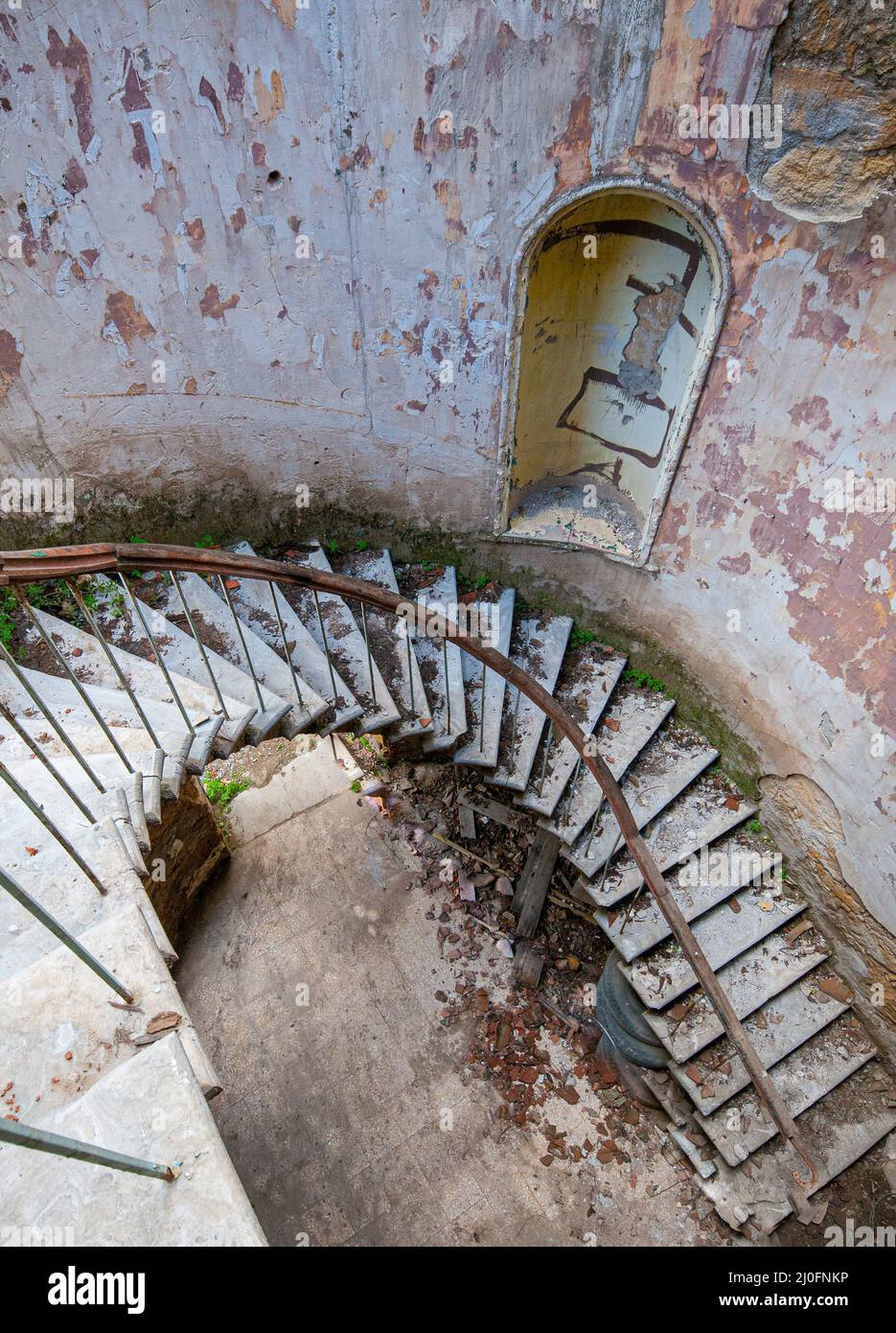 Ricci spirale danneggiato scale di una casa abbandonata e collassante Foto Stock
