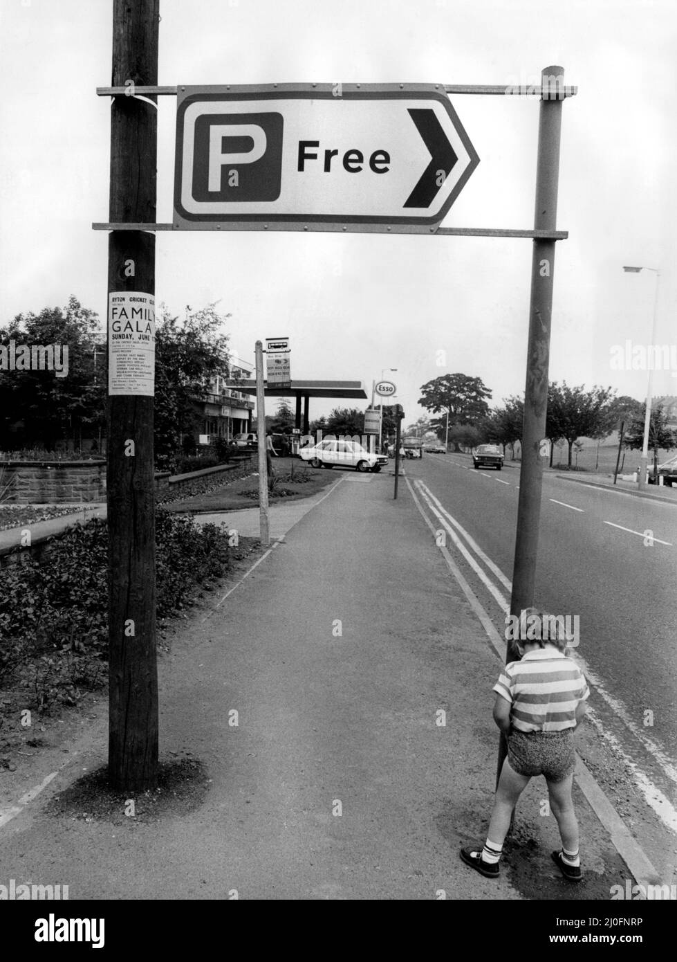 Una foto di una serie di immagini di novità umuristiche scattate dal fotografo domenicale Dennis Hutchinson. Un ragazzo usa un cartello P (parcheggio gratuito) come un tolietto. Circa: 1980 Foto Stock