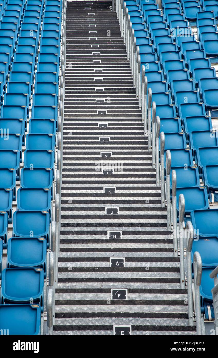 Sedie da stadio vuote in plastica blu di fila Foto Stock