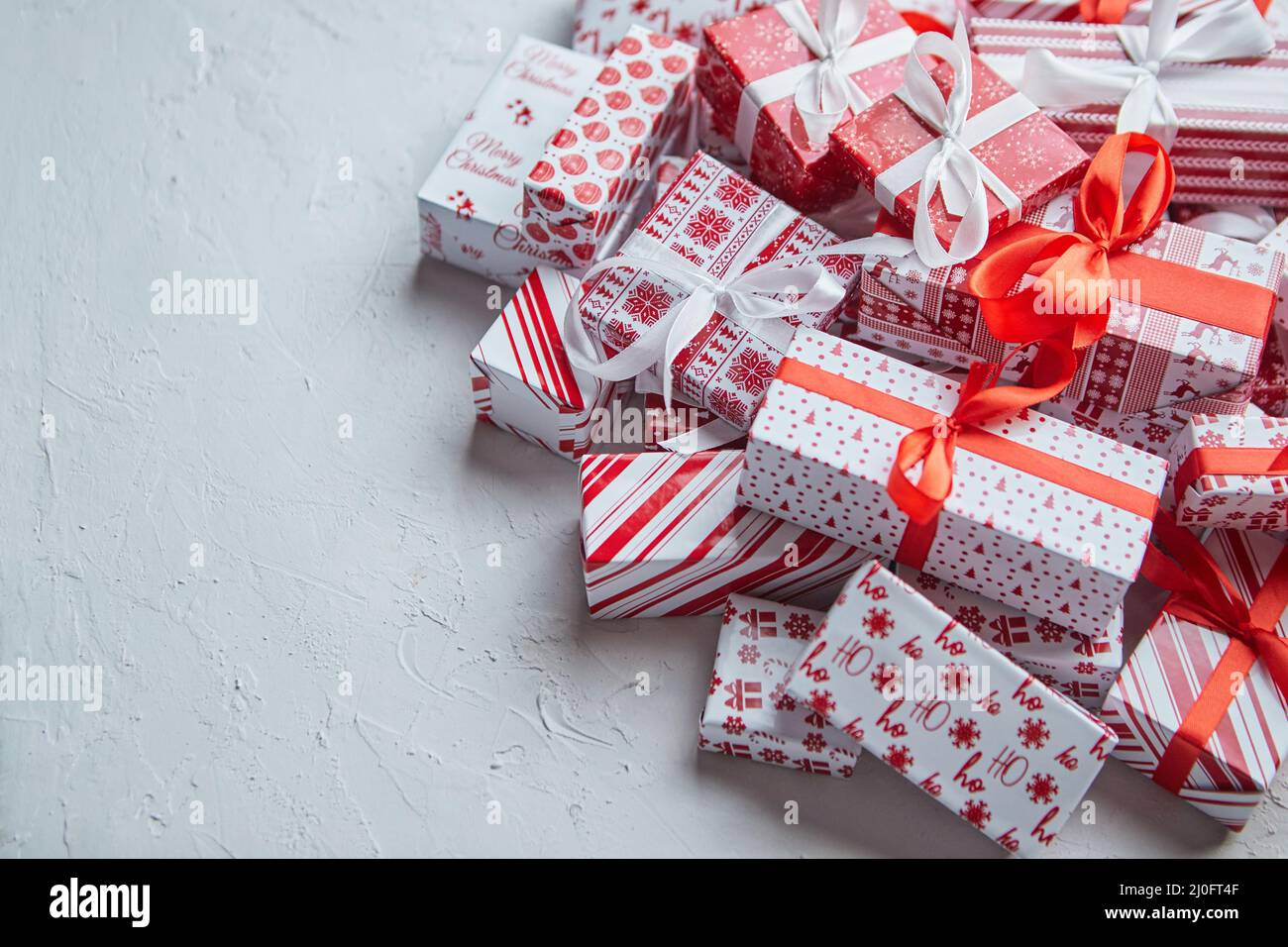 Una pila di varie dimensioni avvolta in regali di carta natalizia messi in pila. Concetto di Natale Foto Stock