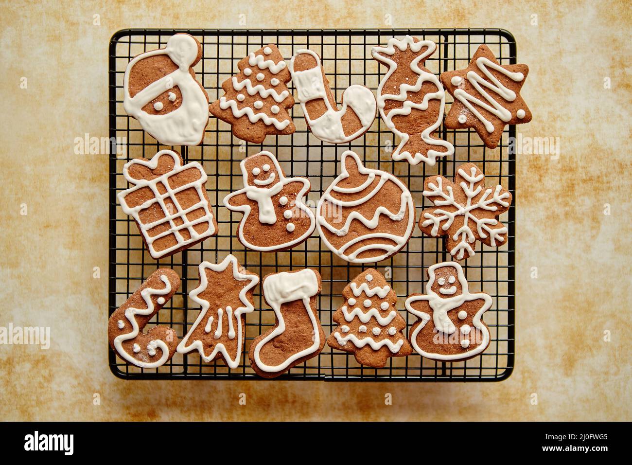 Freschi di forno a forma di Natale gingerbread cookies posto sulla griglia di acciaio Foto Stock