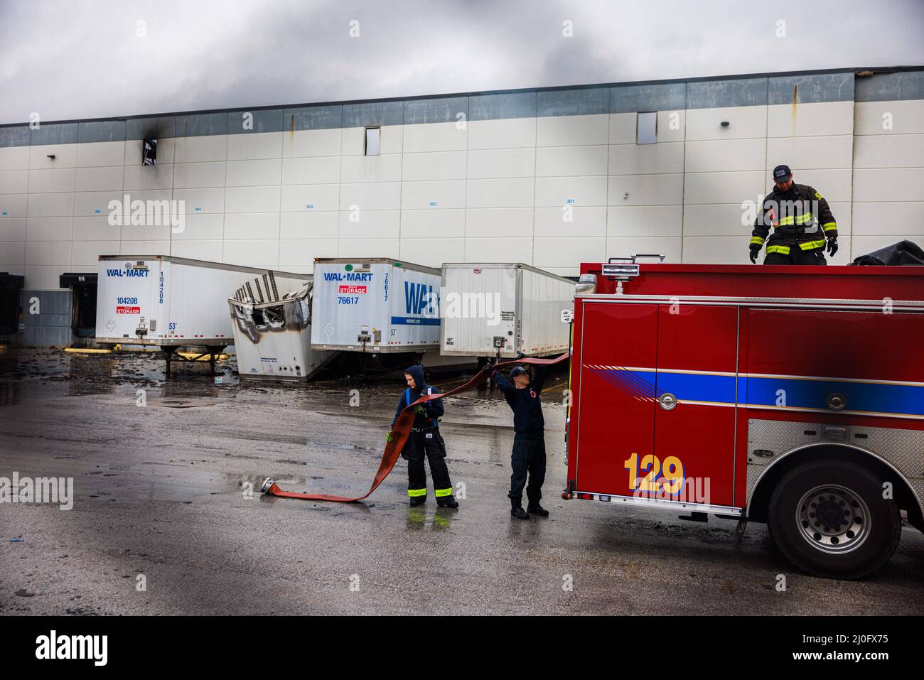 Plainfield, Stati Uniti. 18th Mar 2022. I membri del Plainfield Fire Territory caricano le manichette dopo un incendio che distrusse il Walmart Fulfillment Center a Plainfield, Ind. Il fuoco nell'edificio di 1,2 milioni di piedi quadrati è iniziato mercoledì intorno a mezzogiorno e non è stato contenuto fino a venerdì. Il Bureau of Alcohol, Tobacco, armi da fuoco ed esplosivi (ATF) indagherà la causa del fuoco. Nessuno è stato ferito nella macchia. Credit: SOPA Images Limited/Alamy Live News Foto Stock