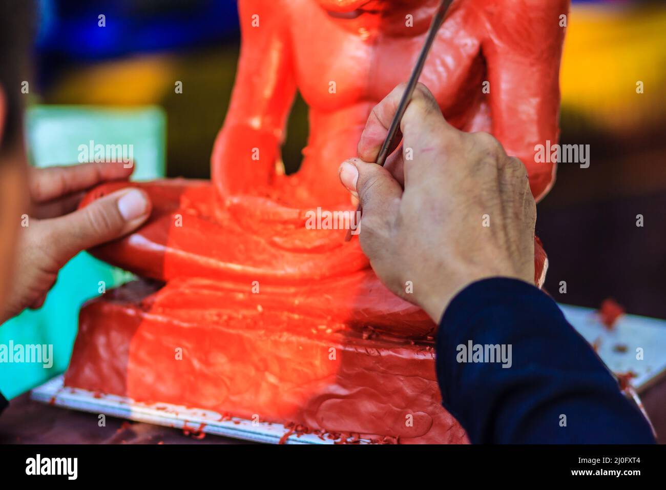 Scultore che intagliano l'immagine del monaco di argilla. Artista di scultura thailandese che modella e intagliano l'argilla per fare la famosa immagine del monaco. L'artigiano Foto Stock