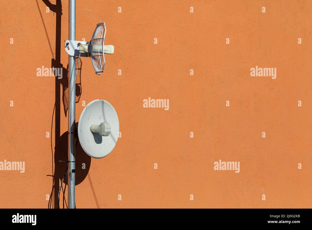 Due antenne per telecomunicazioni utilizzate per la rete cellulare e la connessione Internet wireless, fissate sulla parete dell'edificio. Ricezione e cifra Foto Stock