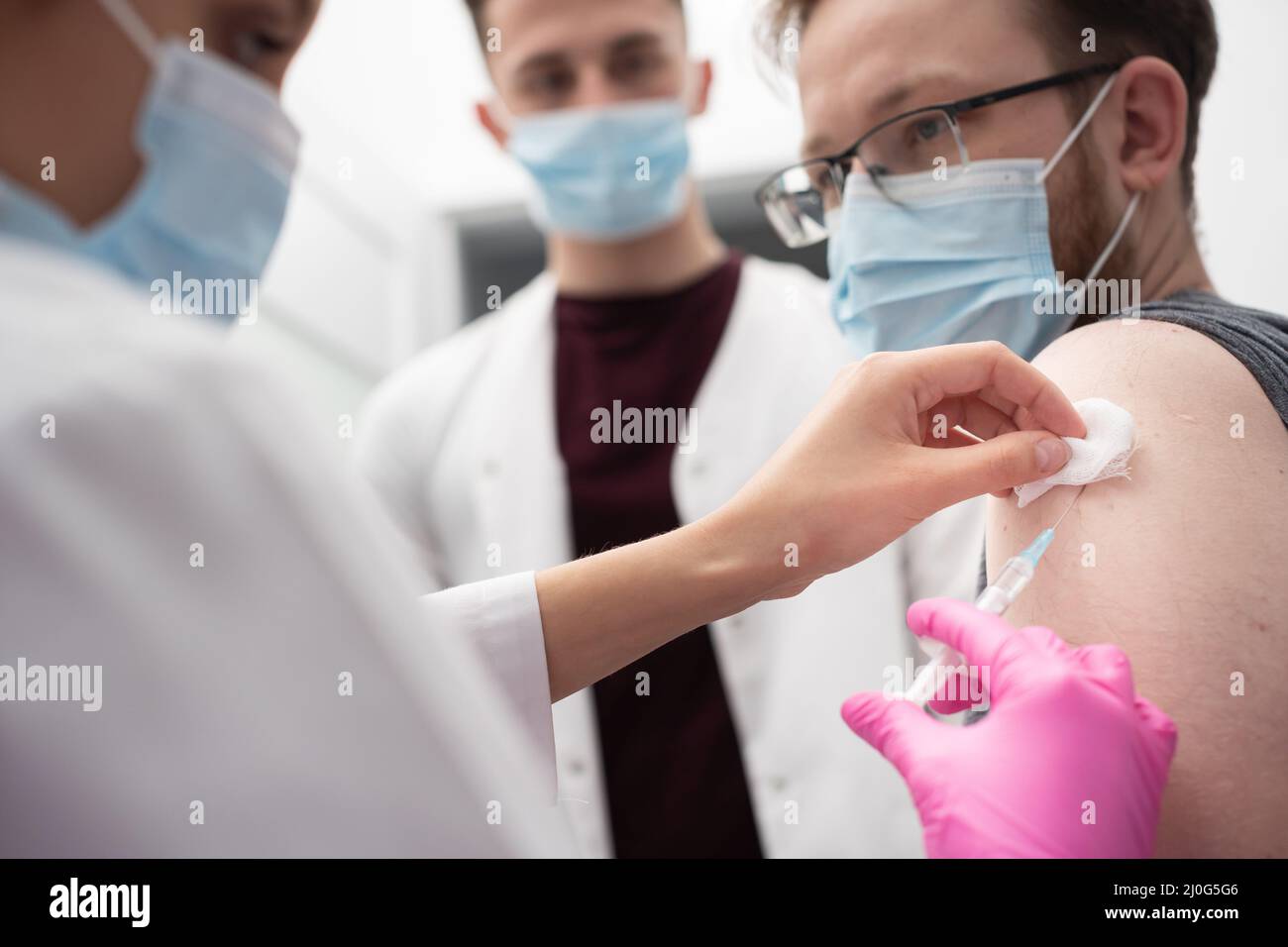 Un giovane infermiere mostra a un medico internista come somministrare correttamente le iniezioni. Un ufficio medico sterile in una clinica privata. T Foto Stock