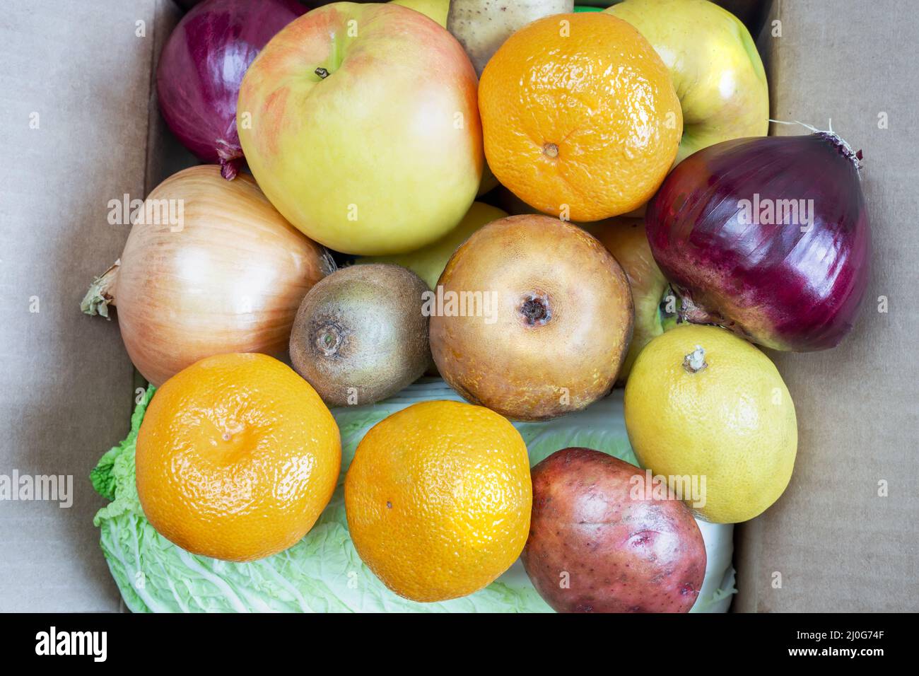 Scatola di cartone con una varietà di verdure e frutta. Foto Stock