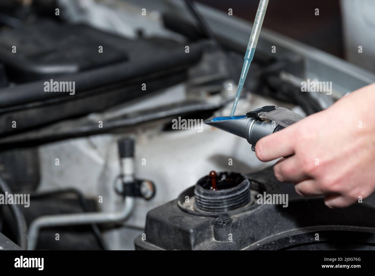 Il tecnico dell'auto controlla il liquido di raffreddamento - tecnologia automobilistica, dettagli Foto Stock