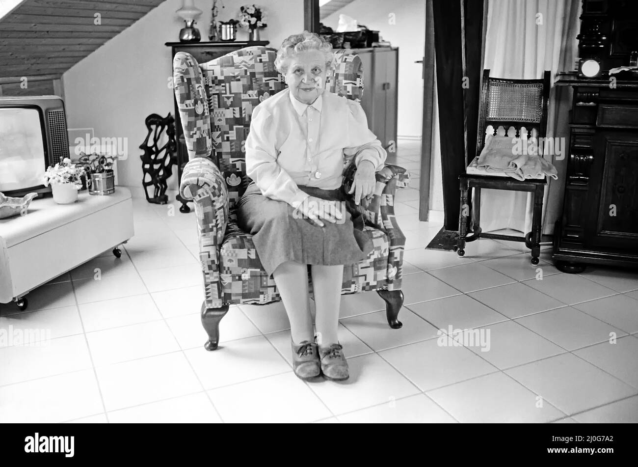 ritratto di simpatica sorridente nonna di novanta anni seduta nella sua poltrona Foto Stock
