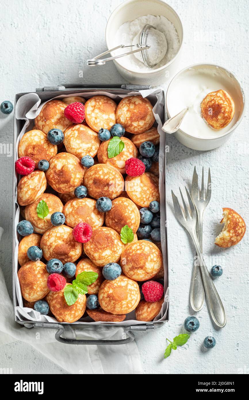 Deliziose e mini pancake fatti in casa con frutti di bosco freschi. Colazione con mini pancake e frutti di bosco. Foto Stock