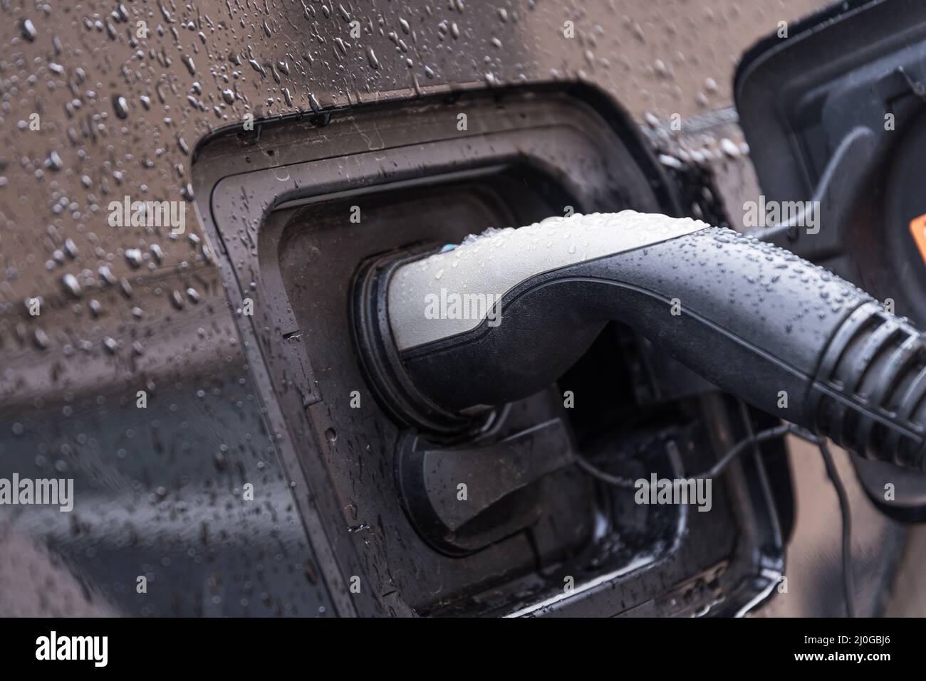 Auto elettrica collegata alla stazione di ricarica - primo piano Foto Stock
