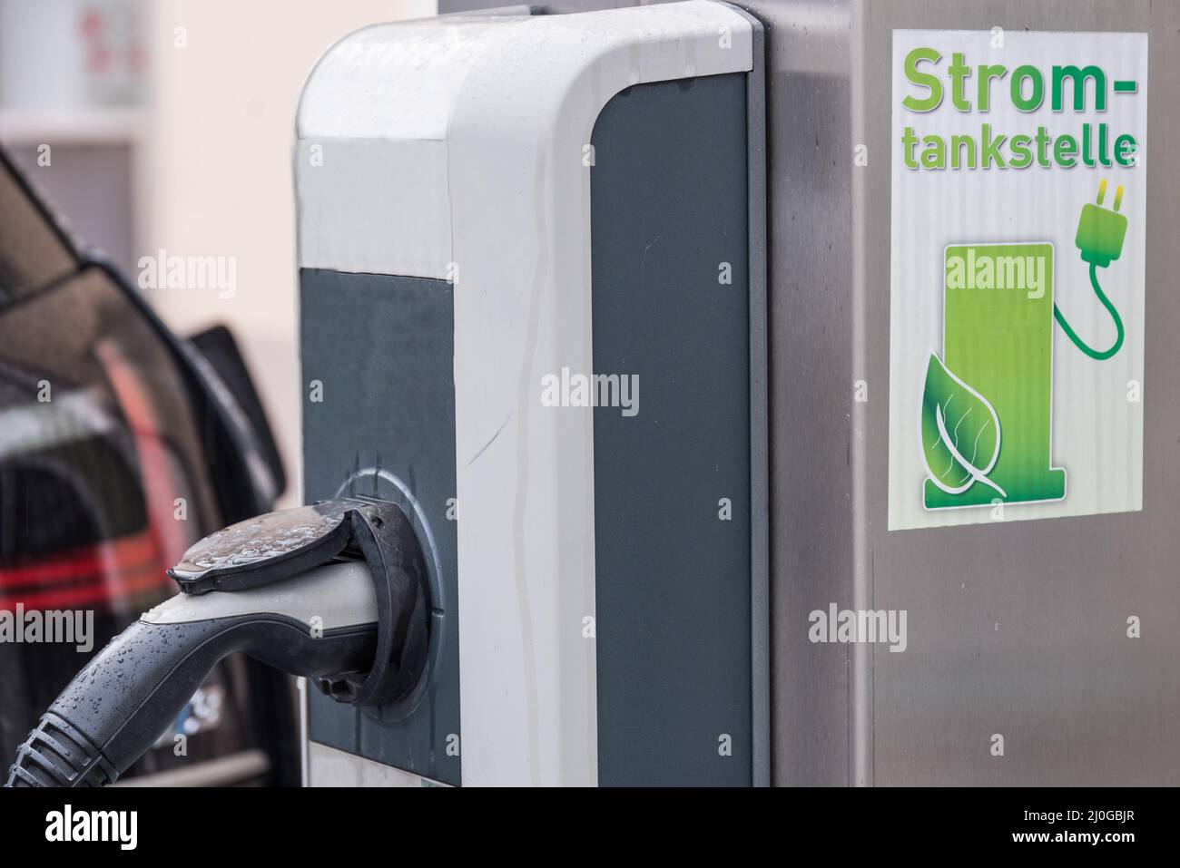 Auto elettrica collegata alla stazione di ricarica - primo piano mobilità elettrica Foto Stock