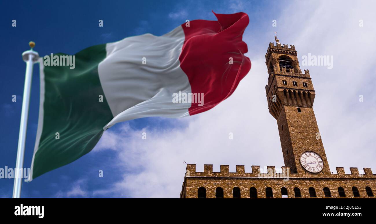La bandiera italiana sventola nel vento con la torre di Palazzo Vecchio a Firenze sullo sfondo Foto Stock