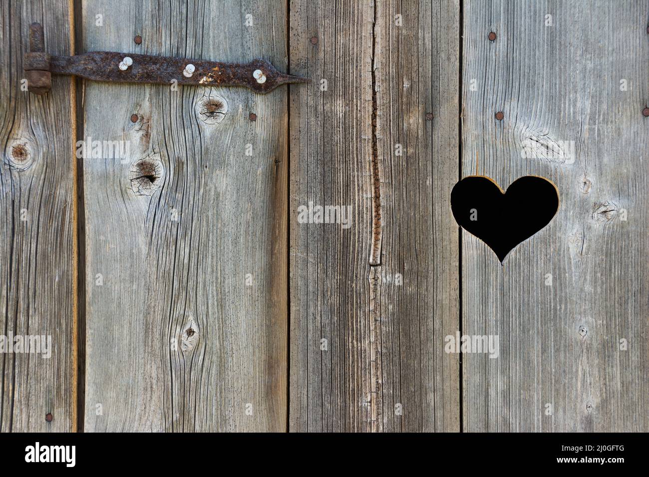 Vecchia porta di legno con cuore Foto Stock