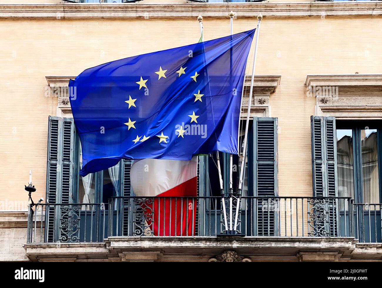 La bandiera della Comunità europea che sorvola la bandiera italiana sul balcone di un edificio pubblico Foto Stock