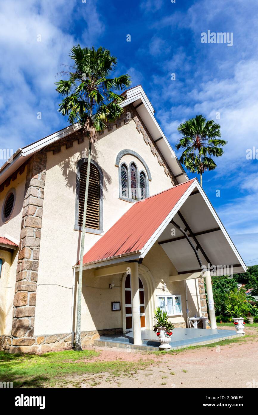 Chiesa cattolica di Sant’Anna a Baie Ste Anne, Isola di Praslin, Seychelles, edificio in bianco stile coloniale con palme. Foto Stock