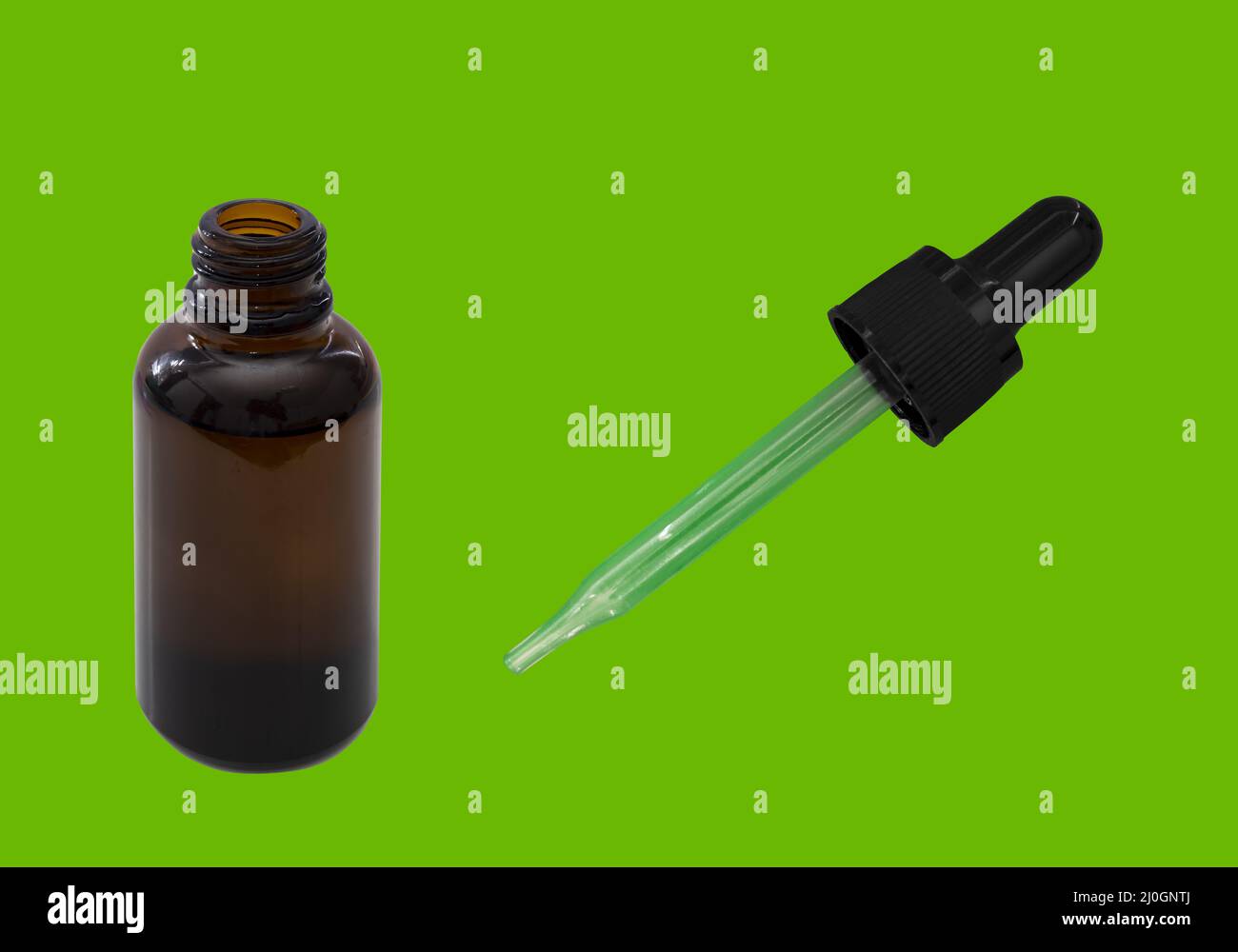 Una bottiglia di ambrato di olio di cannabis aperta su un tavolo verde. Chiave Chroma Foto Stock