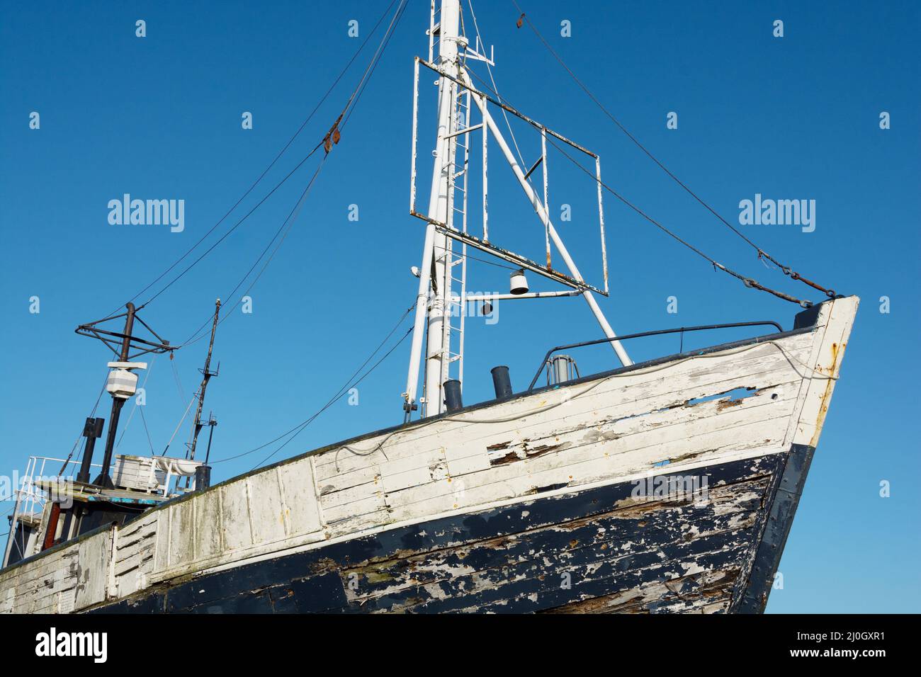 Vecchia barca da pesca abbandonata a riva Foto Stock