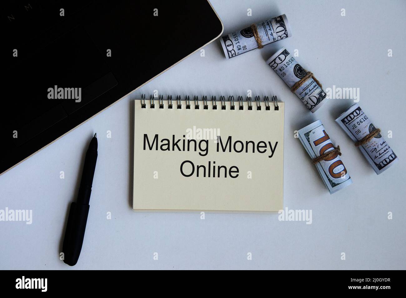 Fare soldi in linea testo su blocco note con soldi e sfondo del laptop. Concetto di business online Foto Stock