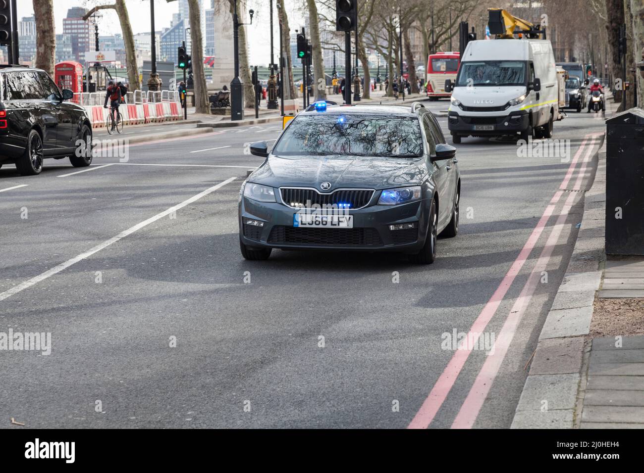 Un'auto di polizia senza contrassegno che mostra le luci blu lampeggianti velocità ad un incidente a Westminster, Londra, Inghilterra, Regno Unito Foto Stock