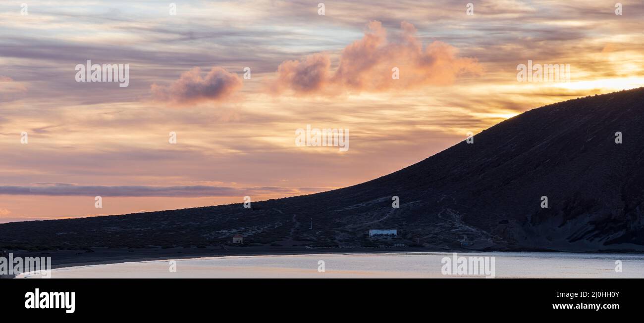 Montana Roja, montagna rossa, si staglia all'alba, alba dalla spiaggia a la Tejita, Tenerife, Isole Canarie, Spagna Foto Stock