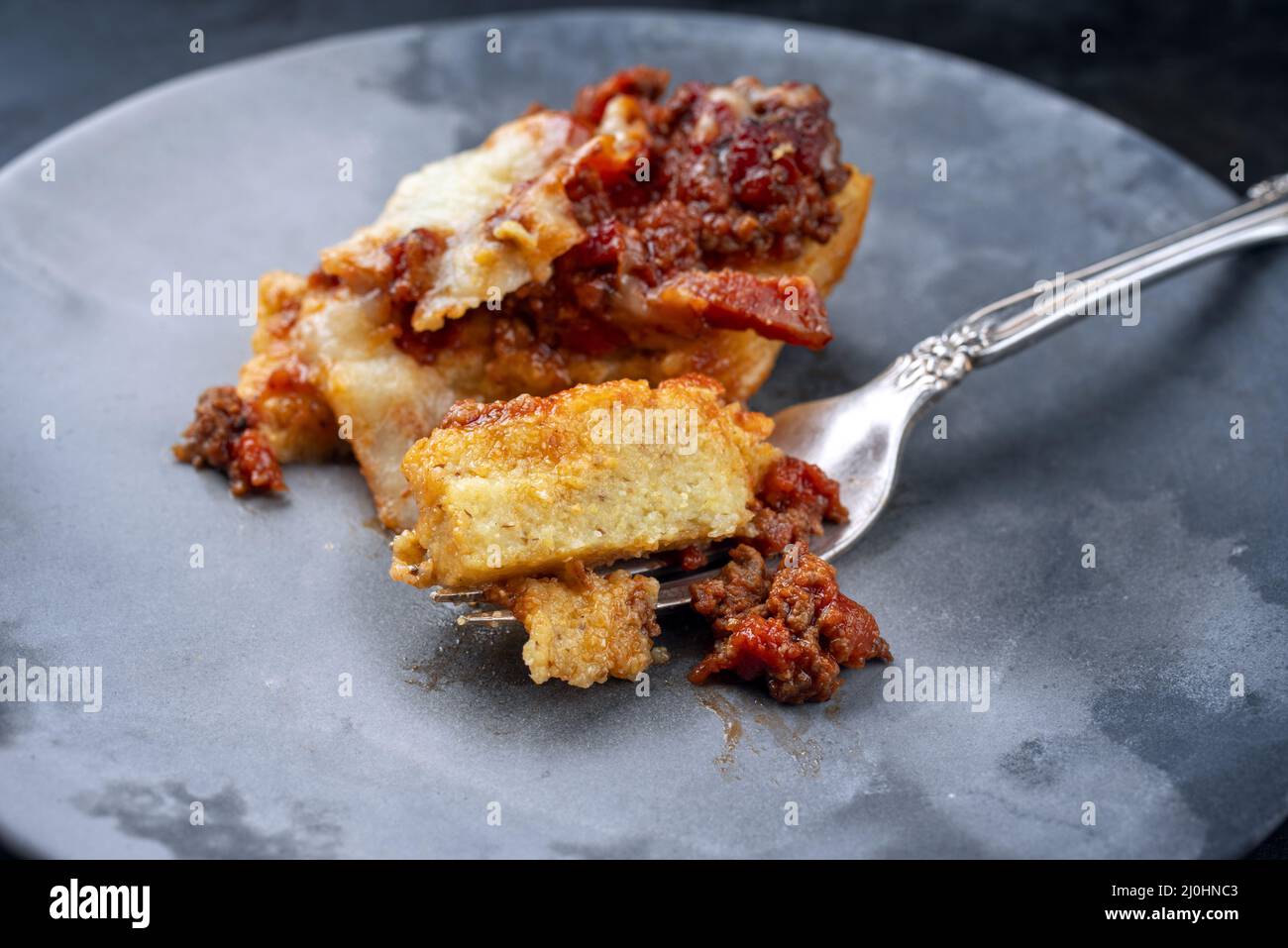 Tradizionale polenta italiana alla sarda con salsiccia in stile moderno con ragù di carne macinata e pecorino servito come vista dall'alto su un cer Foto Stock