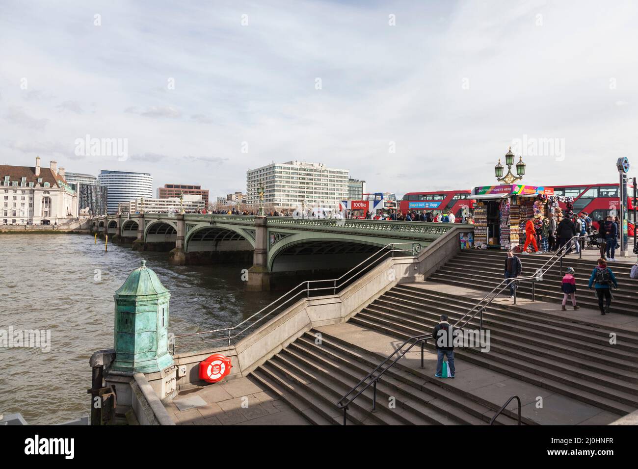 Una vista del Ponte di Westminster, Londra, Inghilterra, Regno Unito che mostra autobus rossi, turisti e bancarelle di souvenir. Fiume Tamigi Foto Stock