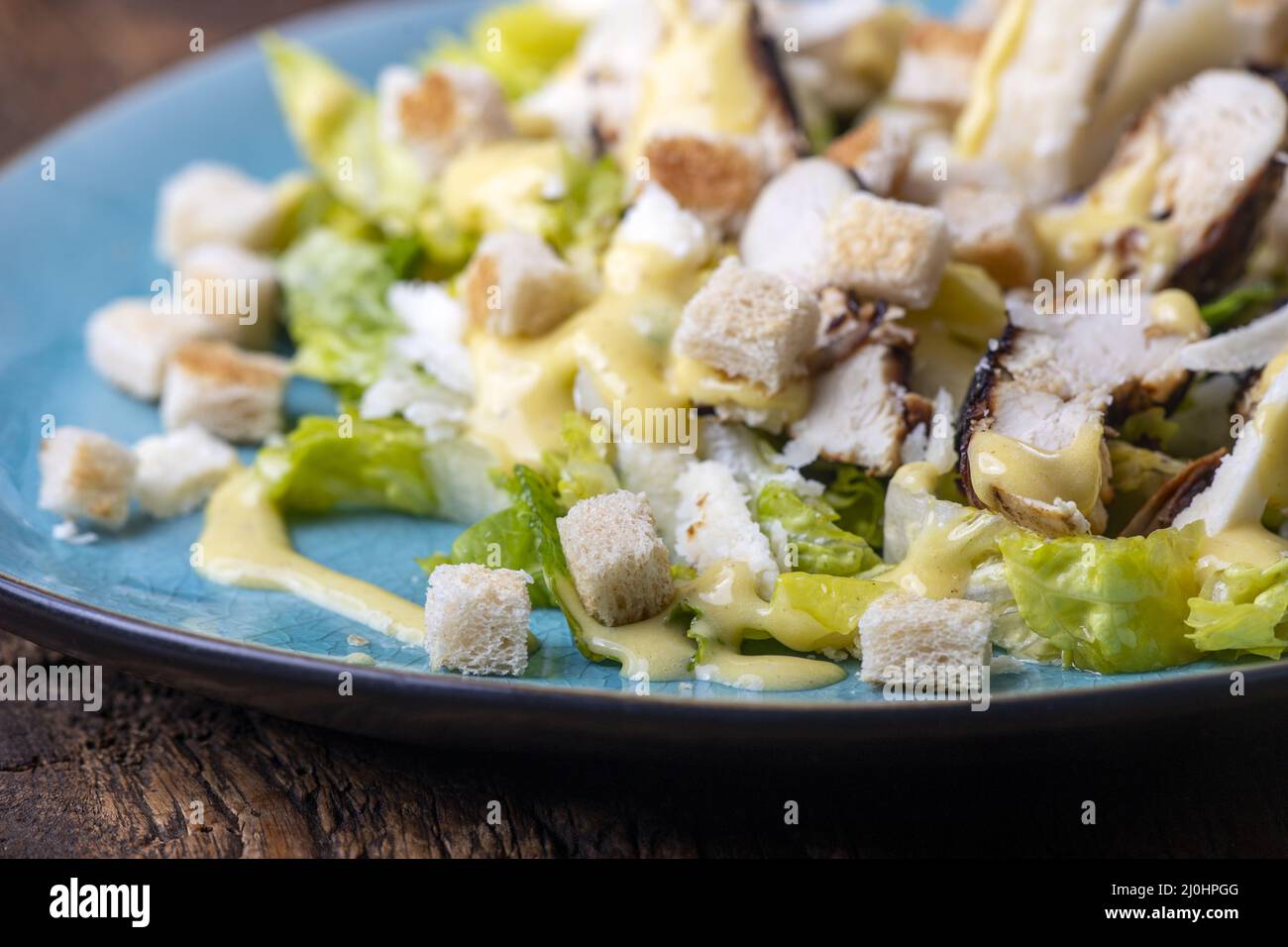 Insalata Caesar su piatto blu Foto Stock