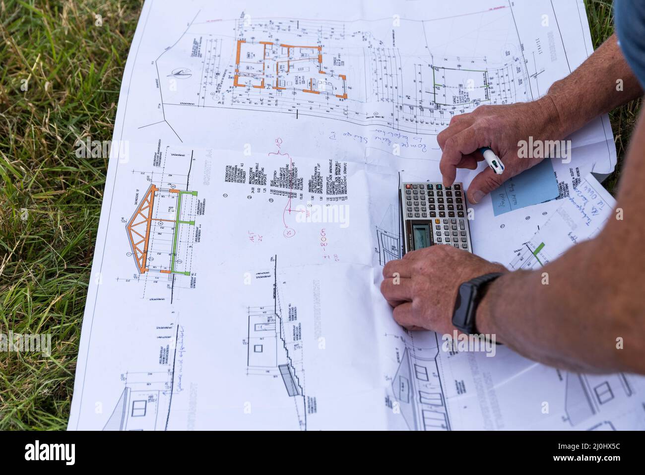 Handyman con pianta della casa sul cantiere - primo piano lavoratore di costruzione Foto Stock