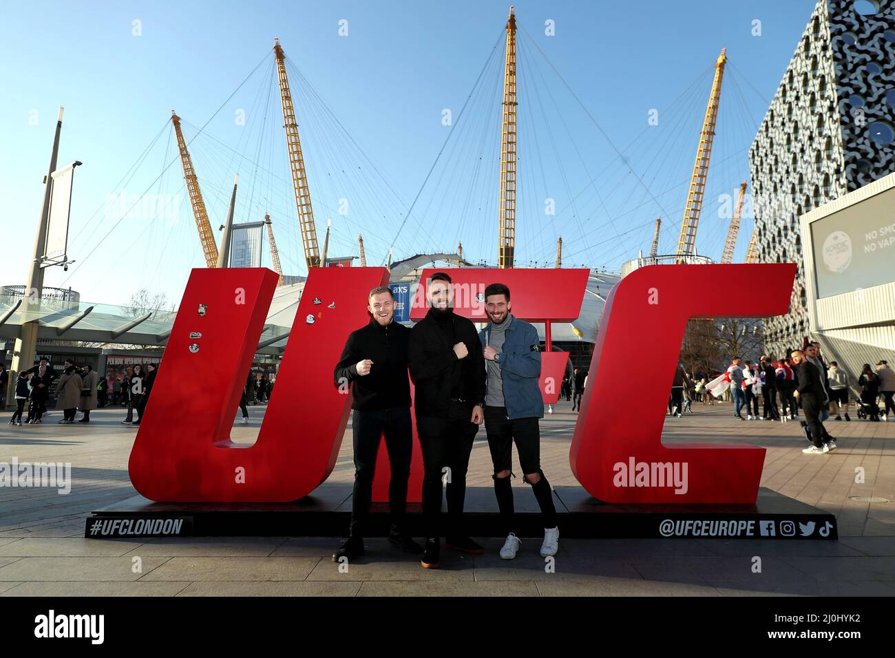 I fan posano con la segnaletica UFC fuori dal O2, Londra prima della notte di combattimento UFC. Data foto: Sabato 19 marzo 2022. Foto Stock