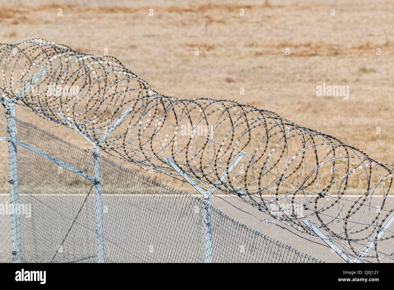 una recinzione di filo spinato per proteggere un bordo Foto Stock