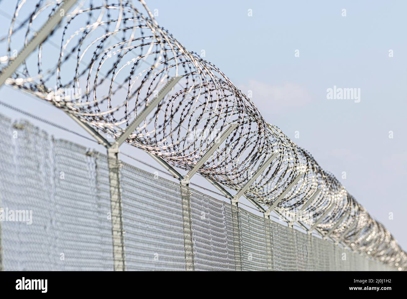 una recinzione di filo spinato per proteggere un bordo Foto Stock