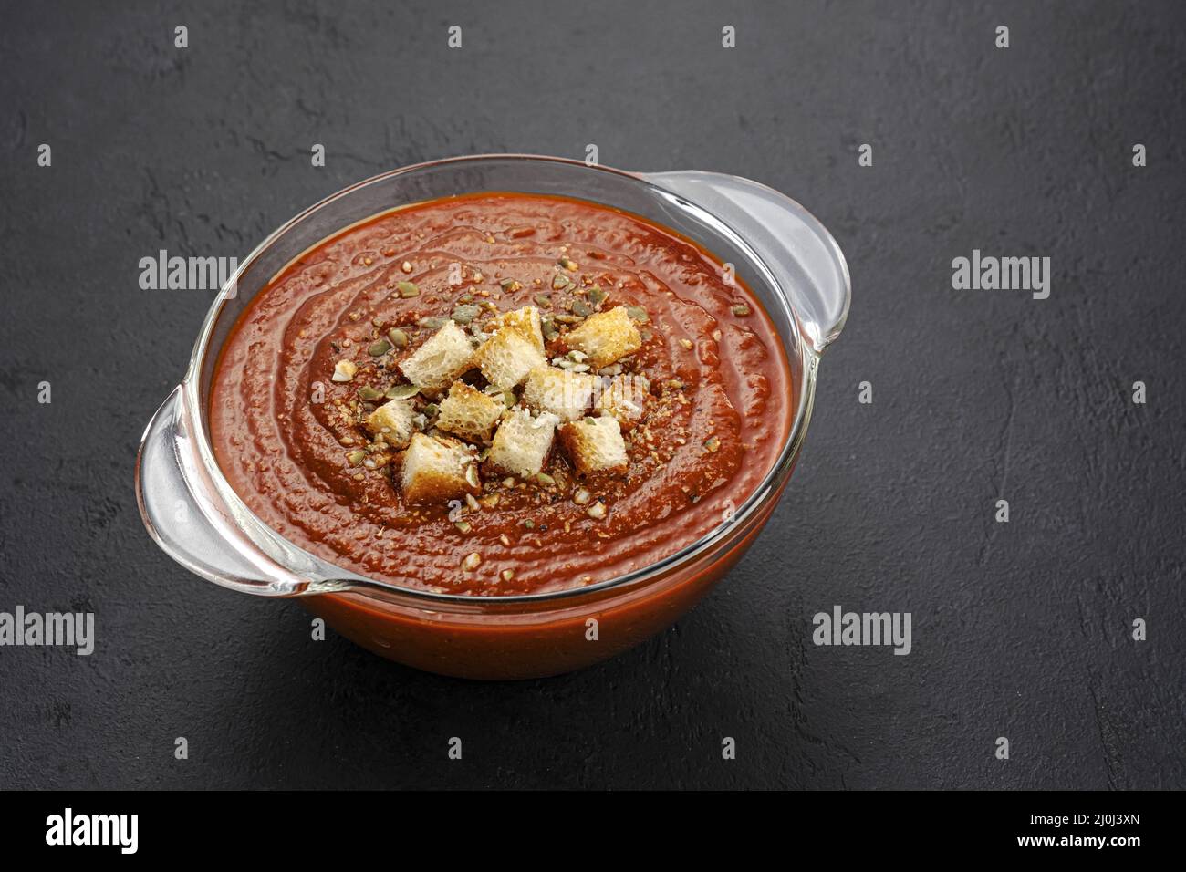 Ciotola di zuppa di pomodoro su fondo nero Foto Stock