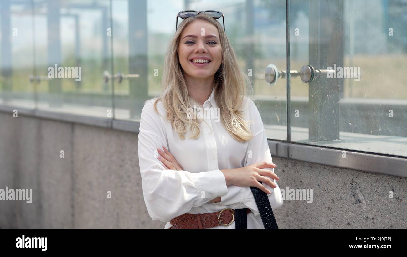 Giovane donna d'affari che cammina fuori dall'edificio moderno Foto Stock