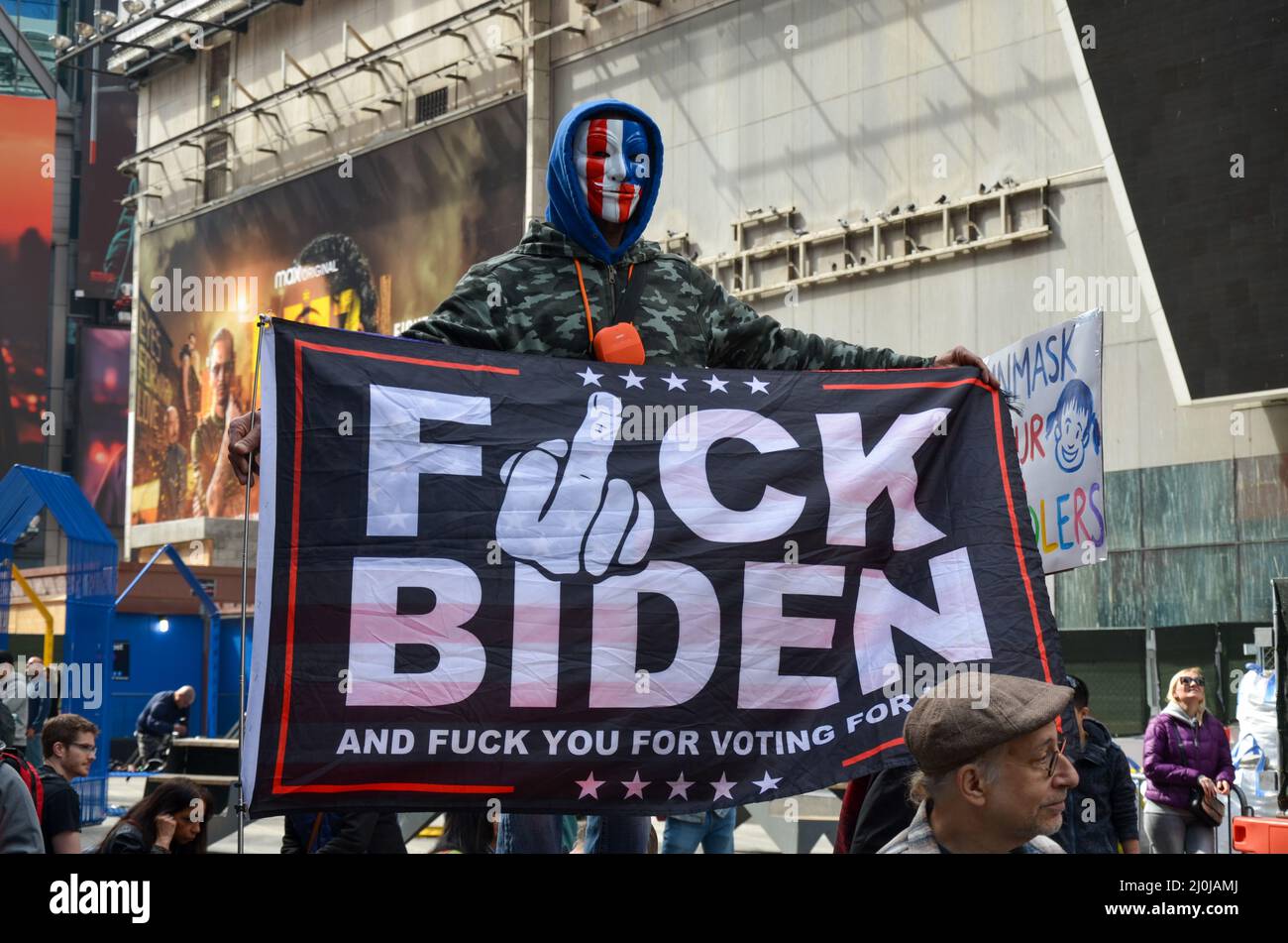 Un dimostratore è visto tenere un anti-Biden bandiera a Times Square a New York City per denunciare Covid19 vaccino e Mandati il 19 marzo 2022. Foto Stock