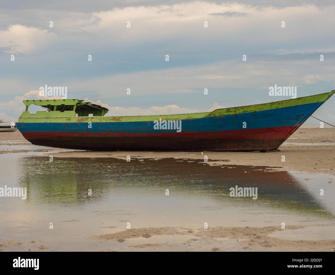 Kaimana, Arguni Bay, Indonesia - Febbraio 2018: Colorate barche di legno sulla spiaggia a bassa marea al porto di una piccola città sul capo degli uccelli Peninsul Foto Stock