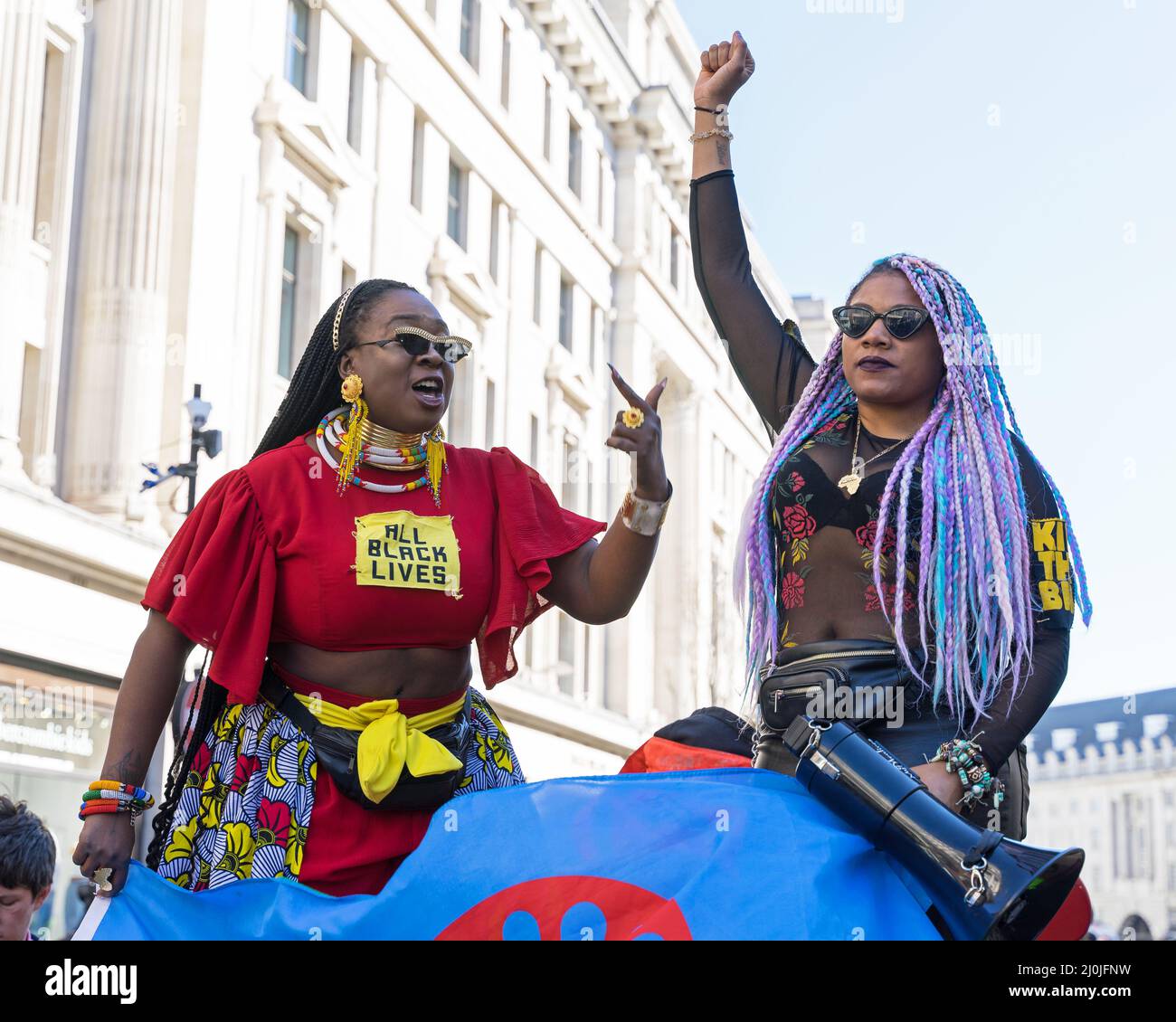 Protesta contro il razzismo per le strade di Londra. Due donne di colore nero contano i manifestanti che parlano in un megafono. Londra - 19th marzo 2022 Foto Stock