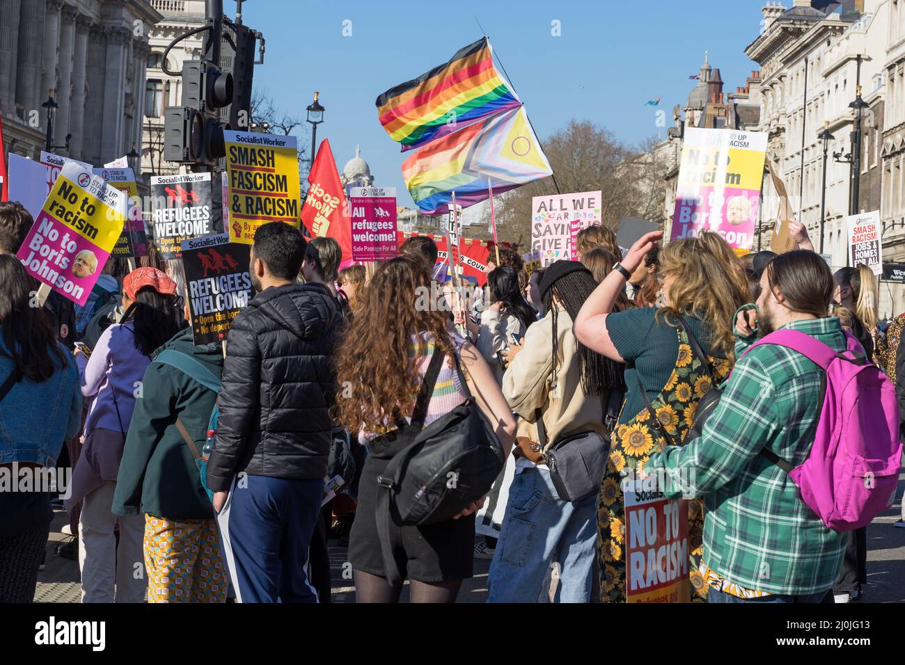 Protesta contro il razzismo per le strade di Londra. Un ampio gruppo di manifestanti che detengono i rifugiati segnali di benvenuto e bandiere LGBTQ. Londra - 19th marzo 2022 Foto Stock