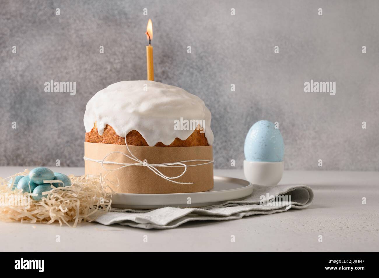 Torta tradizionale pasquale fatta in casa, nido decorativo con uova blu su sfondo grigio con spazio copia. Biglietto di auguri. Foto Stock