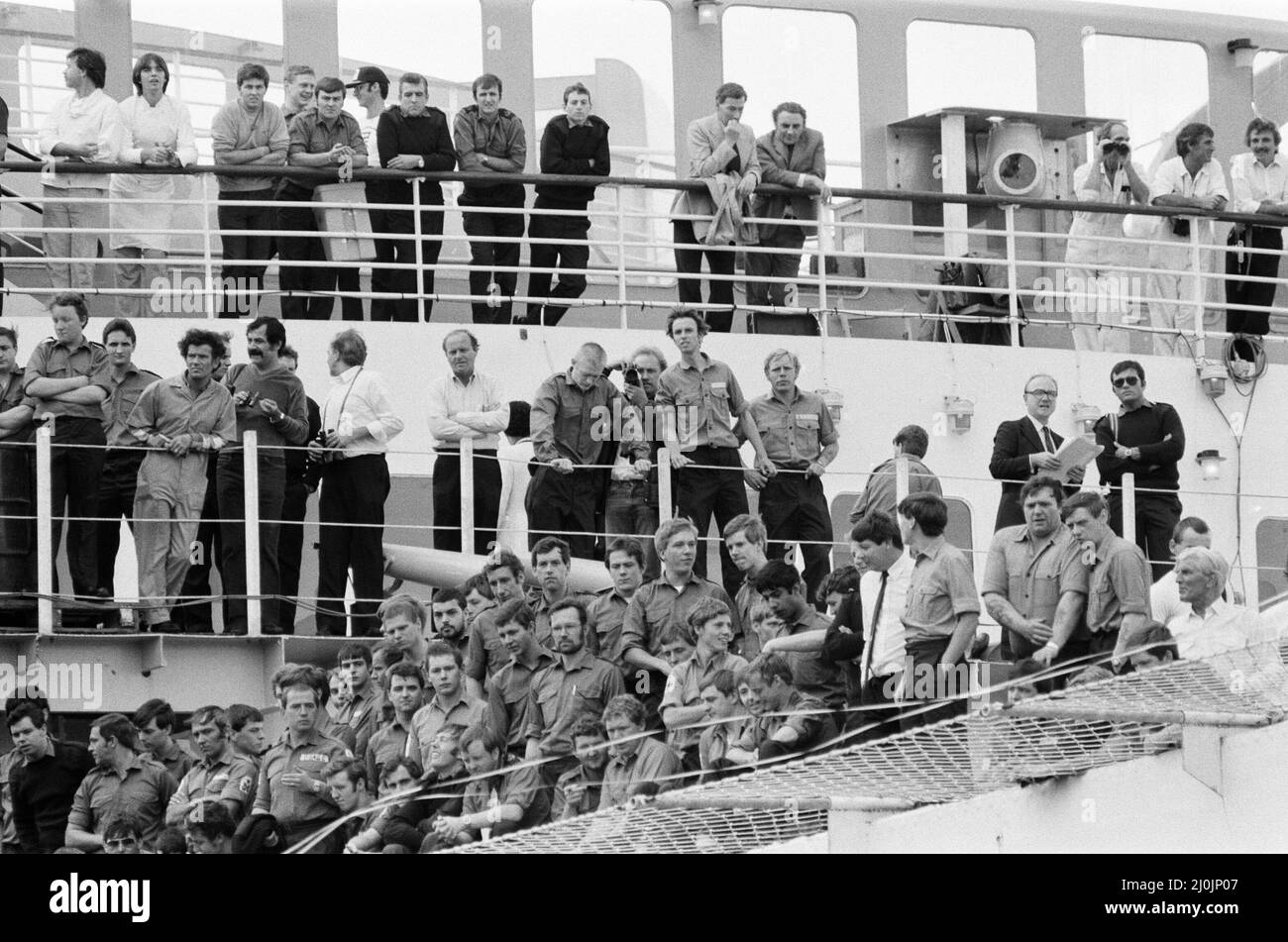 Il QE2 torna a casa a Southampton. Union Jacks è festooned sulle automobili, drappeggiato sulle spalle, ondulato sui bastoni. Southampton dà il benvenuto a "Three Cheers" al QE2 lussuoso liner trasformato in trooper di ritorno dalla guerra. A bordo è il suo prezioso carico, i 700 sopravvissuti della HMS Coventry, ardent e Antelope, affondati nella battaglia per le Falklands. 11th giugno 1982. Foto Stock