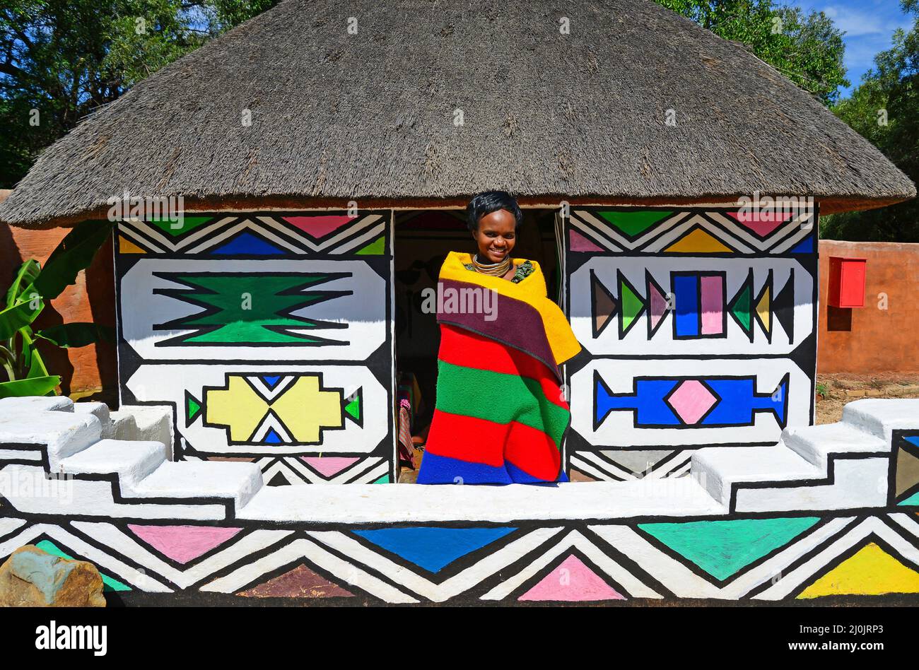 Ndebele donna e capanna a Motseng Villaggio Culturale, Sun City Resort, Pilanesberg, nord ovest della provincia, Repubblica del Sud Africa Foto Stock