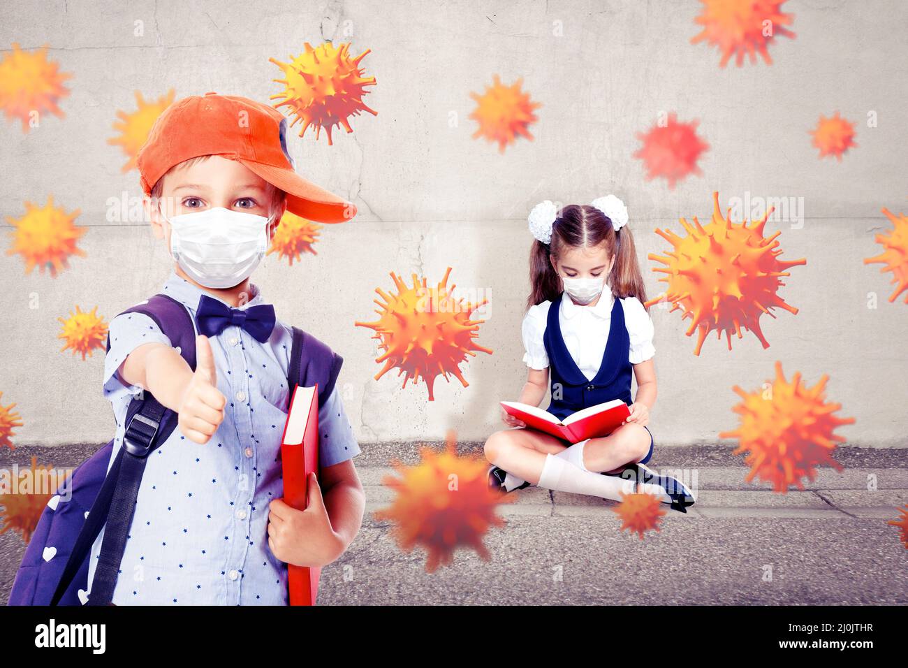 Bambini piccoli con maschere di protezione contro il virus corona a scuola. Foto Stock