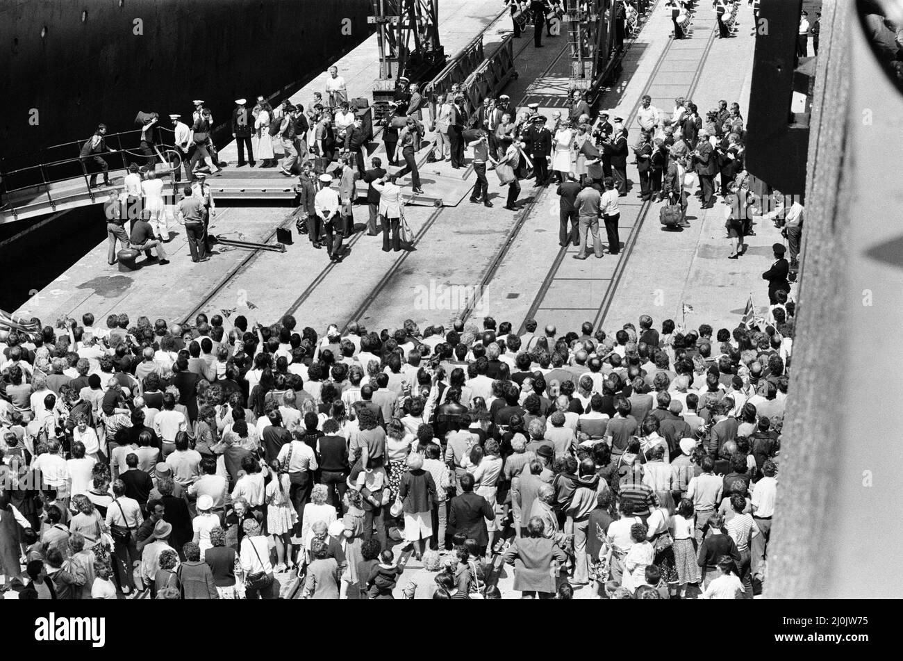 Il QE2 torna a casa a Southampton. Union Jacks è festooned sulle automobili, drappeggiato sulle spalle, ondulato sui bastoni. Southampton dà il benvenuto a "Three Cheers" al QE2 lussuoso liner trasformato in trooper di ritorno dalla guerra. A bordo è il suo prezioso carico, i 700 sopravvissuti della HMS Coventry, ardent e Antelope, affondati nella battaglia per le Falklands. 11th giugno 1982. Foto Stock